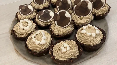 Homemade chocolate tartlets with coffee cream, several topped with chocolate discs showing the MReye logo
